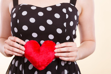 Woman in dotted dress holding red heart