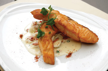Close up of seared salmon with leek carbonara sauce. Selective focus.
