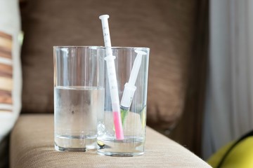 medicine syringe in glass on table, child for health concept