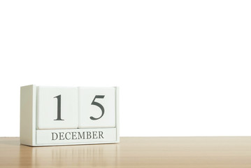 Closeup surface white wooden calendar with black 15 december word on blurred brown wood desk isolated on white background with copy space , selective focus at the calendar