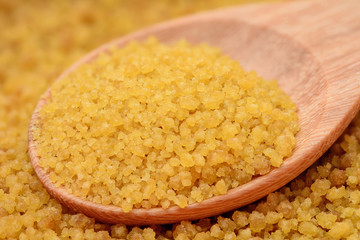 brown sugar heap on wooden spoon