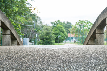 Closeup old stone floor at the bridge in the park with blurred park view textured background