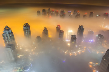 Rare early morning winter fog above the Dubai Marina skyline and skyscrapers ahead of sunrise in Dubai, United Arab Emirates.