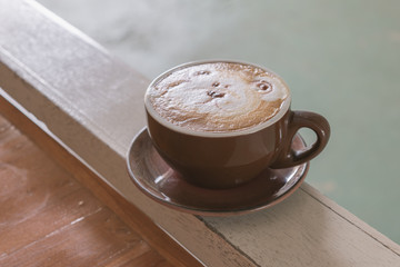 Close up white cup of Coffee with bear hand drawn on top, Coffee latte on the wooden.