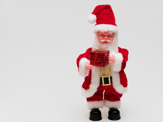 Toy Santa Claus holding a red gift box isolated on white background