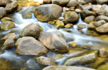 Fototapeta na wymiar Water flowing over rocks in dry evergreen forest,thailand.