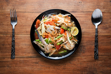 spicy papaya salad with crab and thai Vermicelli, chopsticks, on wooden table, Thai food