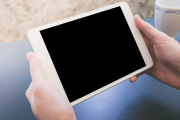 Close up of Male hands using Tablet touch computer gadget on the desk
