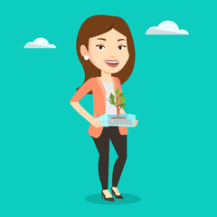 Woman holding plant growing in plastic bottle.