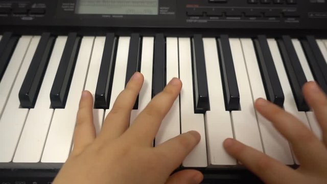 Close up of two child's small hands playing piano HD