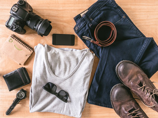 Top view of Men's casual outfits with accessories on wooden table