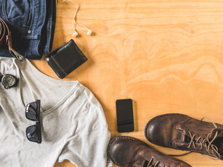 Top view of Men's casual outfits with accessories on wooden table