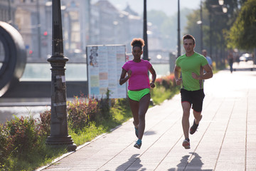 young smiling multiethnic couple jogging in the city