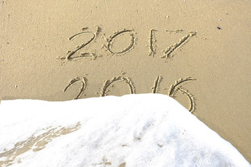 Good bye 2016 hello 2017. inscription written in the beach sand.