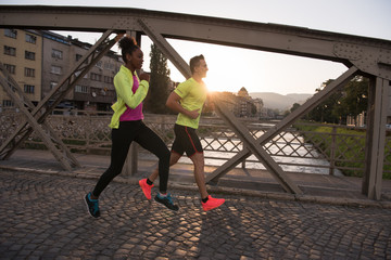 Obraz premium young multiethnic couple jogging in the city