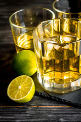 glass of whiskey on dark wooden background