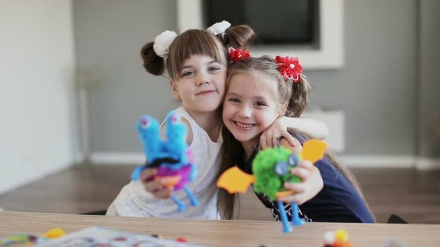 two girls smiling, embracing and looking at the camera