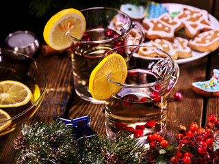 Fototapeta na wymiar Glasses with hot punch and lemon. Plate with Christmas cookies is in the background of still life.