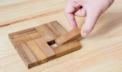 Hand-picked pieces of wooden blocks to complete metaphor for unity, the key to success