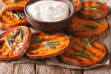 Grilled sweet potatoes with sour cream closeup. horizontal