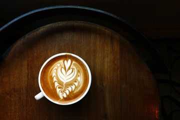 cup of latte art coffee on wooden background
