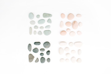 Creative arrangement of colored stones. Mint, pink, beige and grey stones on white. Flat lay, top view