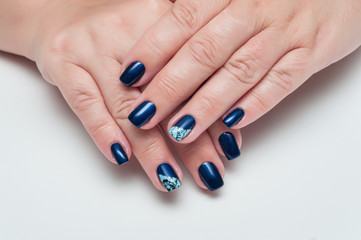 dark blue manicure with cracks on the ring finger