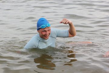 The swimmer in a blue cap rejoices to a victory