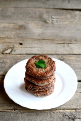 Homemade bean cutlets on a plate isolated on wooden background with copy space for text. Vegetarian cutlets cooked of boiled red beans chopped with a blender, garlic, eggs, flour and spices. Closeup