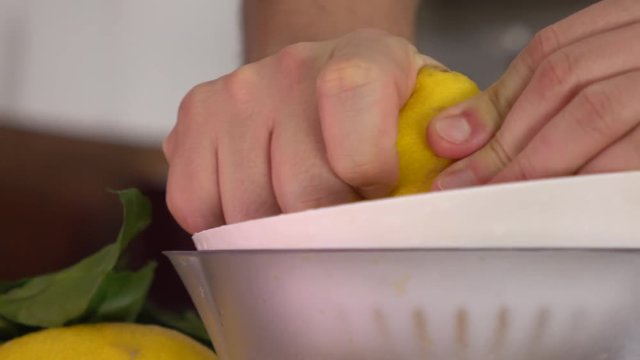 Man making lemon juice with a juicer. 4K close up shot