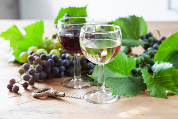 red and white wine and grapes on a table, selective focus