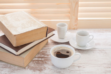 Office workplace with  coffee cup on wooden desk table in front of window with blinds, selective focus
