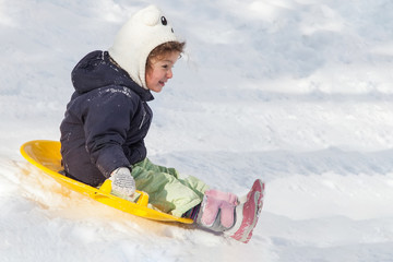 Fototapeta na wymiar Girl sledging down hills winter