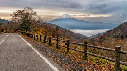 Fototapeta premium Beautiful mount Fuji in autumn color season of trees. The Kawaguchi town and lake below covered with sea of fog.