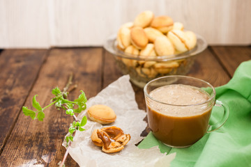 nuts cake with condensed milk and coffee on the table, selective focus