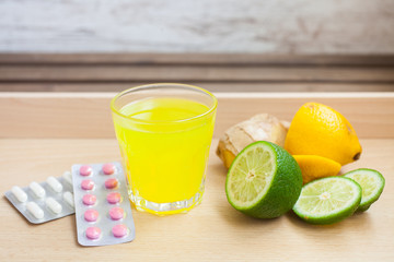 sparkling liquid medicine in a glass and tablets on a table, selective focus