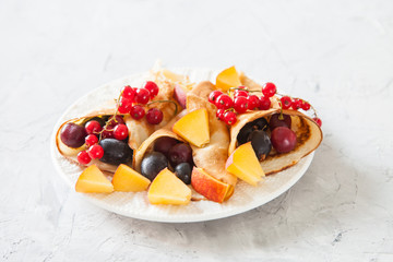 pancakes with berries in a plate on a table, selective focus
