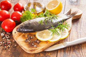 fish with a lemon and tomatoes on a table, selective focus