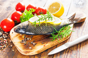 fish with a lemon and tomatoes on a table, selective focus