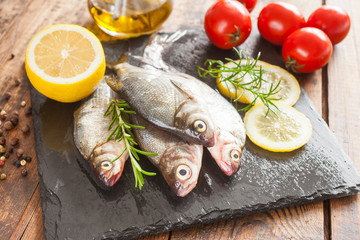 fish with a lemon and tomatoes on a table, selective focus