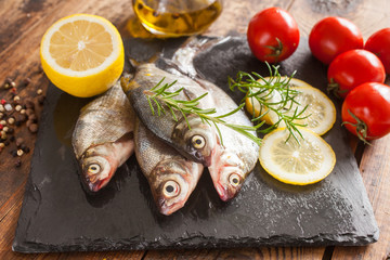 fish with a lemon and tomatoes on a table, selective focus