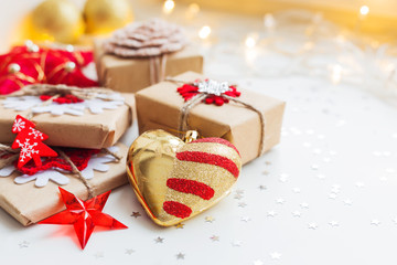Christmas and New Year background with presents and decorative heart for Christmas tree. Holiday background with stars confetti and light bulbs. Place for text.
