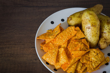 Corn chips with potatoes on the table with nature light in low key tone.