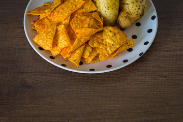 Corn chips with potatoes on the table with nature light in low key tone.