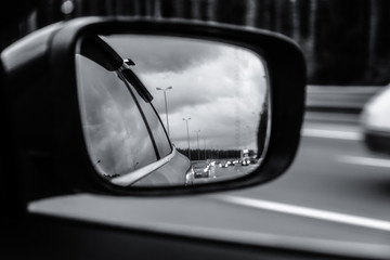 Road reflected in side mirror of car