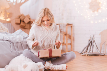 Positive curious woman opening a Christmas box