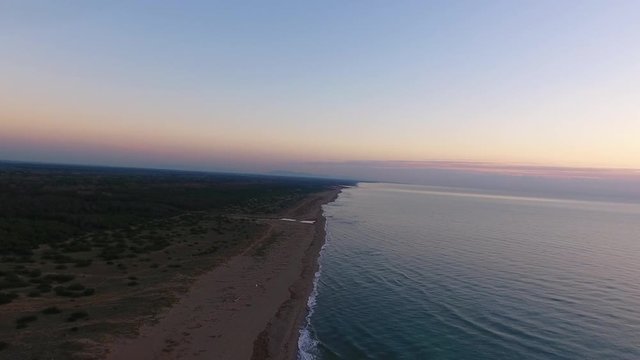 Aerial shot, calm sea and huge beach in the fall on the sunset, filmed with drone