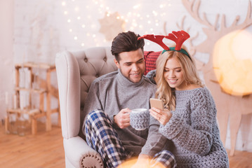 Positive cute woman looking at the screen of her smartphone