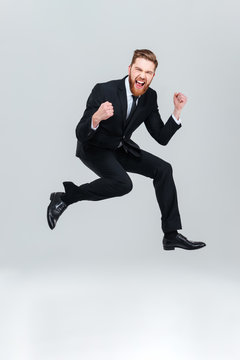 Full length happy business man jumping