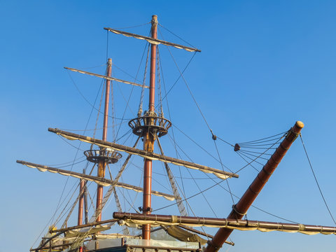 Masts of the ancient sailing ship on the blue sky background